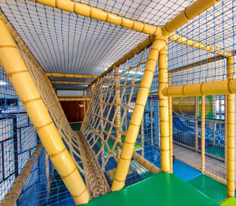 Interior da estrutura de escalada, com redes e túneis